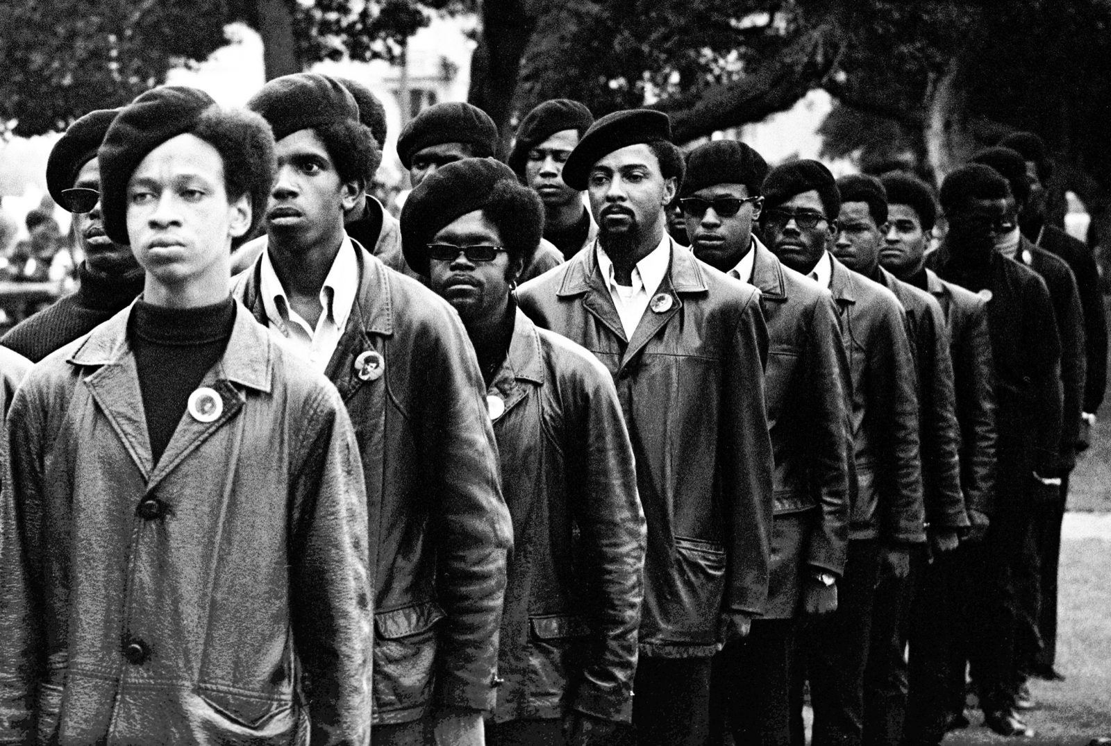 Panthers line up at a Free Huey rally in Defermery Park, in west Oakland‚Äôs ghetto. Light skinned man is Gregory Harrison. His brother, Oleander, went to Sacramento with Bobby & Huey. July 28, 1968