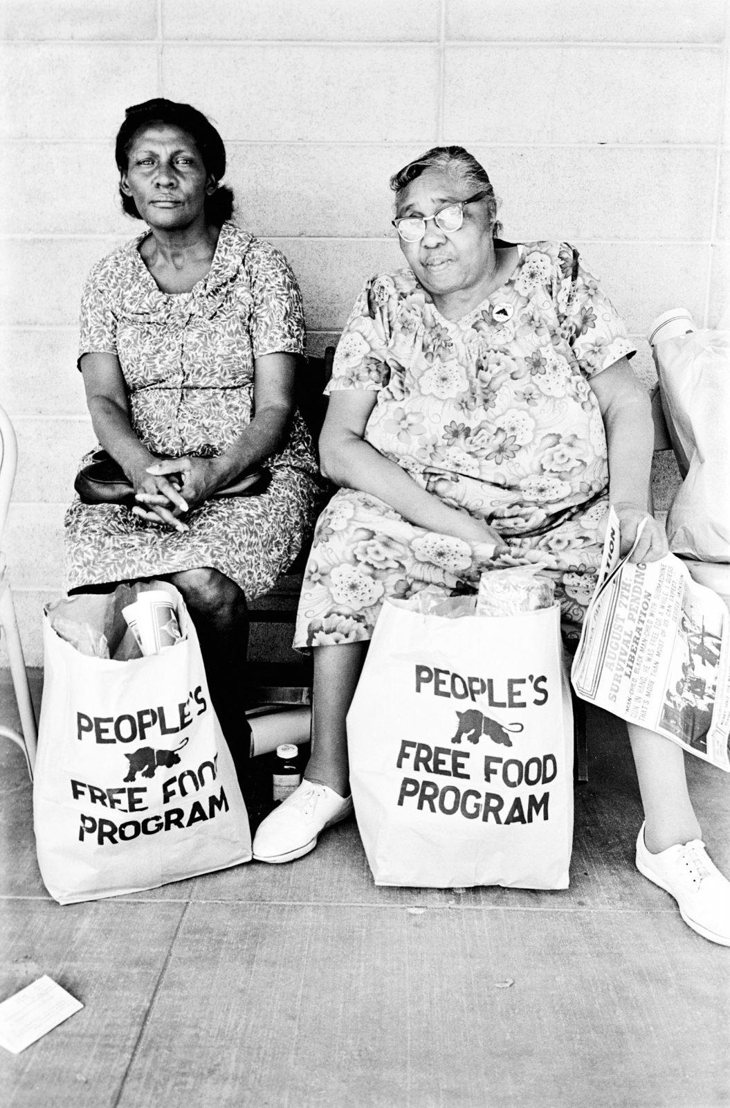 Two women with bags of food at the People's Free Food Program, one of the Panther's survival programs. 1972